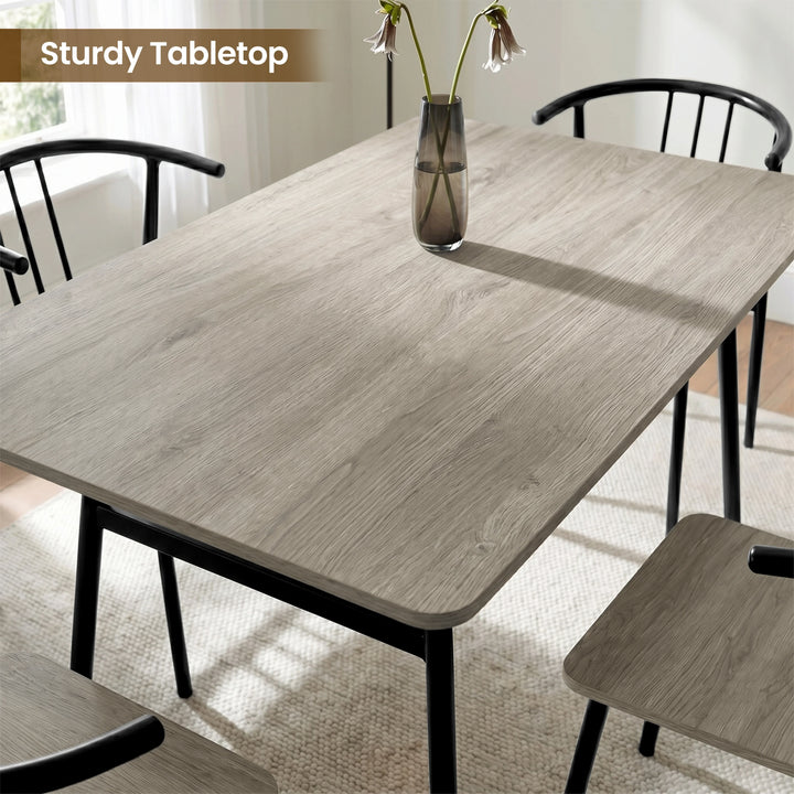 [Grey] Torvi dining table close-up of grey oak MDF surface being wiped clean with a cloth
