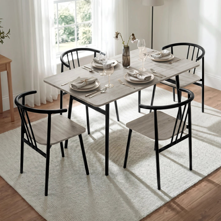 [Grey Oak] Torvi dining table angled close-up of grey oak surface with chairs and vase in a bright dining room