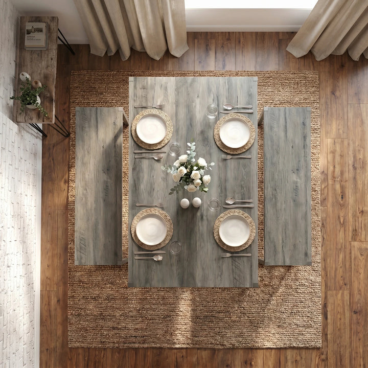 [Grey] Orvak Grey 4 Seater Dining Table With Bench Set seen from directly above showing four woven placemats, white rose centrepiece, and full cutlery layout on jute rug