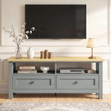[Grey] Oskara TV unit front view in living room below wall-mounted TV styled with blossom vase, white ribbed vase, gold candles, and table lamp