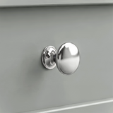 [Grey] Oskara TV unit macro close-up of a polished metallic round drawer knob set against a smooth grey painted shaker-style drawer front