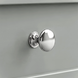 [Grey] Oskara TV unit macro close-up of a polished metallic round drawer knob set against a smooth grey painted shaker-style drawer front
