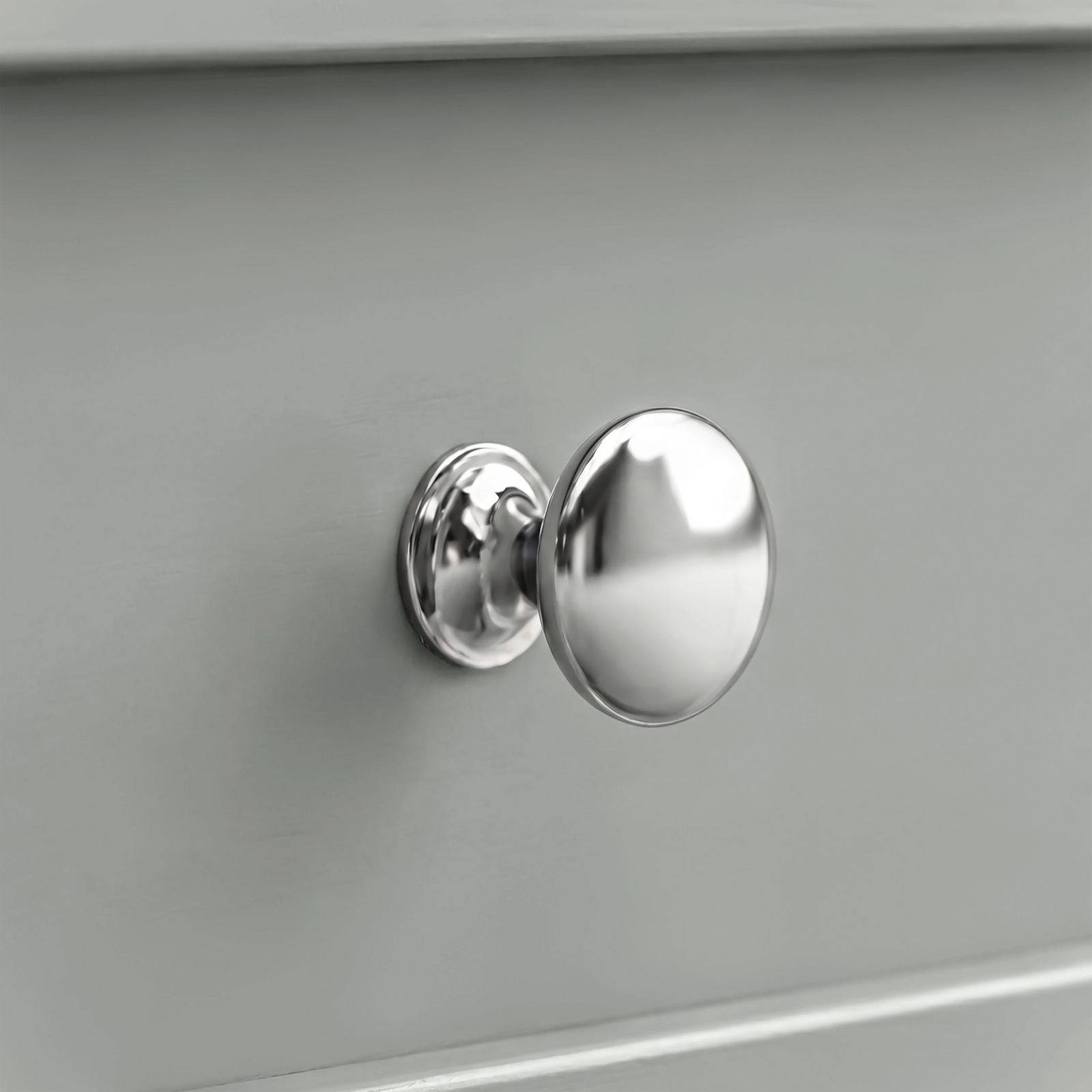 [Grey] Oskara TV unit macro close-up of a polished metallic round drawer knob set against a smooth grey painted shaker-style drawer front