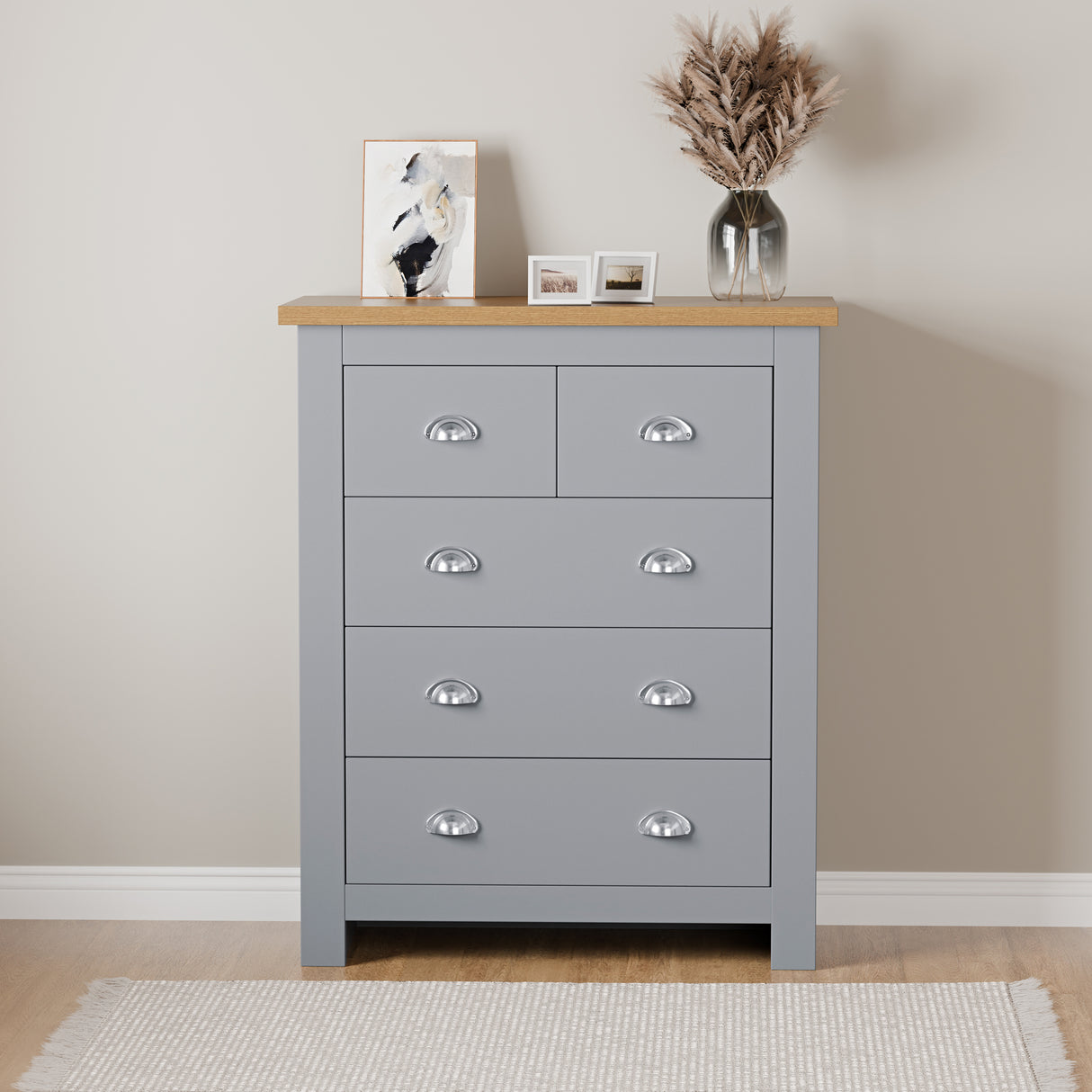 Grey pine chest of drawers with a top surface adorned with a painting and a bottle flower pot.