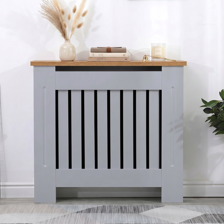 [Small | Grey] Radiator Cover with oak top shelf styled with dried grass, stacked books, and a candle against a bright white wall