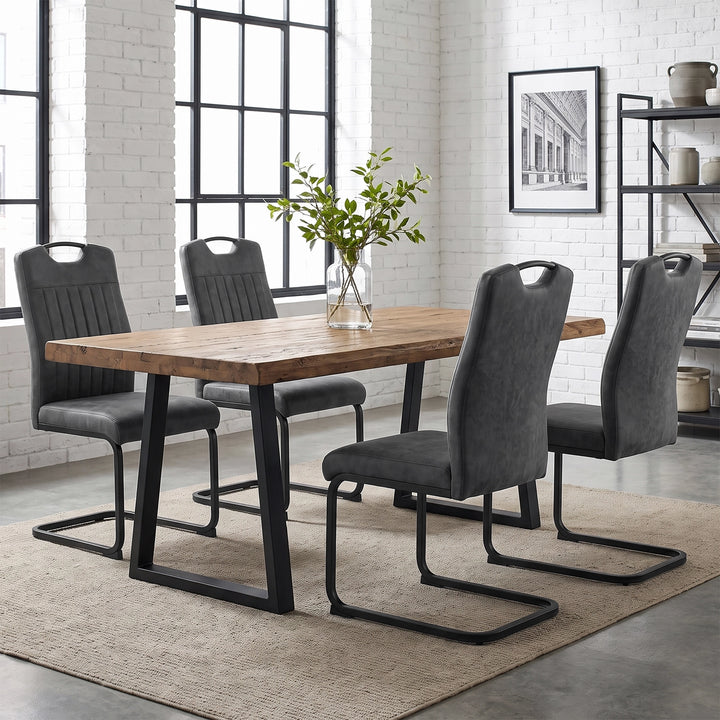 [Grey] Four high-back dining chairs with black loop frames around a wood table styled with a glass plant vase.