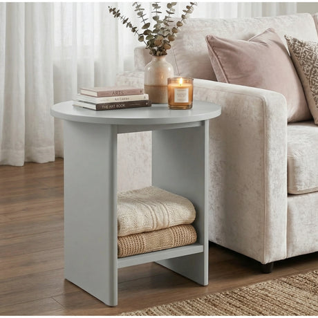 [Grey] Small Round Side Table with Shelf Living Room beside cream sofa with stacked books and lit candle on top and folded throws on lower shelf
