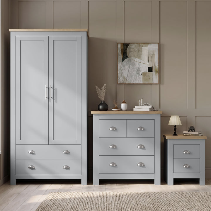 [Grey] Wardrobe, chest and bedside shown together against panelled wall with oak tops, decor, lamp, and rug