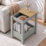 [Grey] Overhead view of open side table storage beside a sofa, with a blossom vase on top and books stored below.
