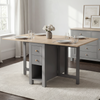[Grey] Stovra Drop Leaf Dining Table fully extended with four place settings and flowers in a bright dining room