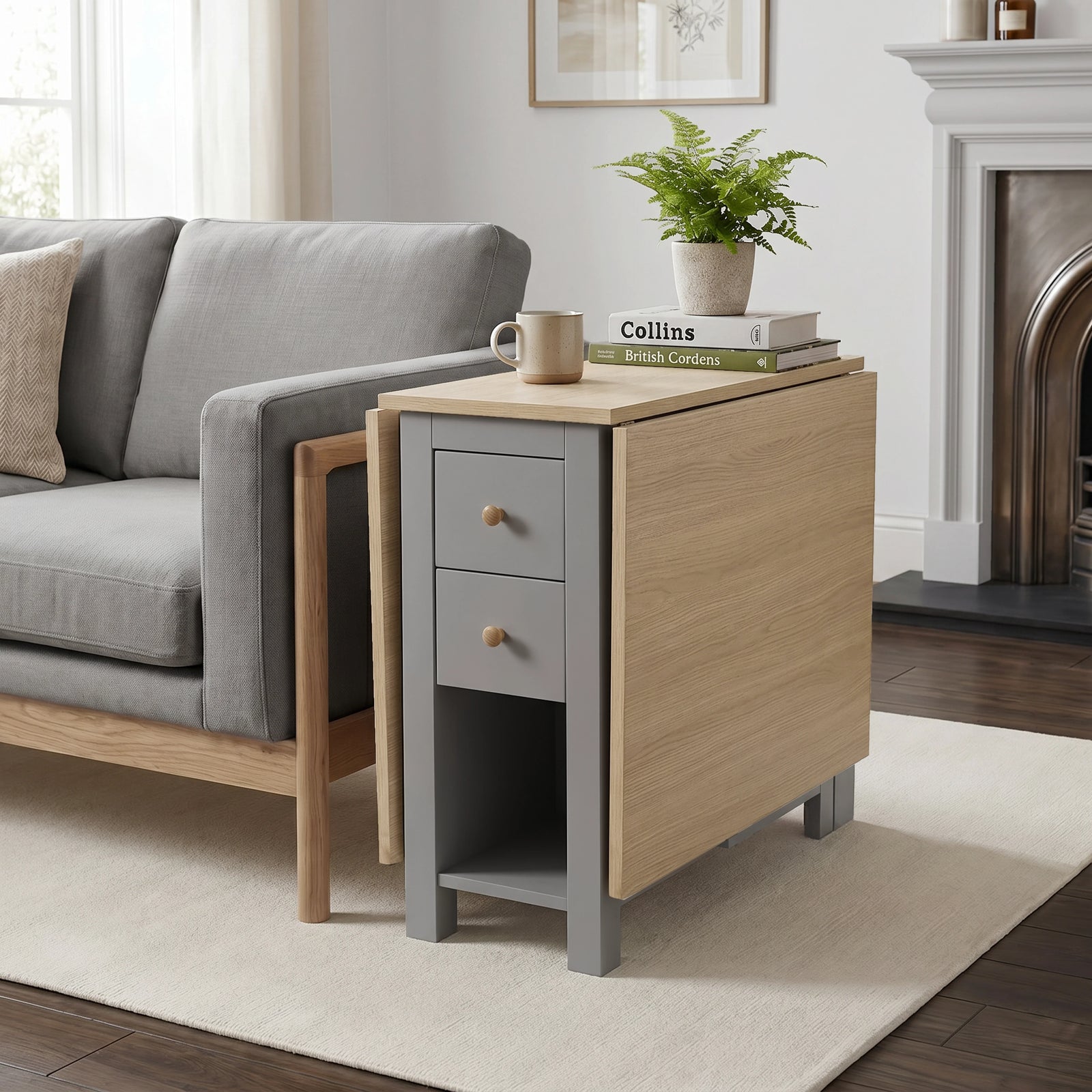 [Grey] Stovra Drop Leaf Dining Table used as a side table beside a sofa with one leaf extended and plant on top