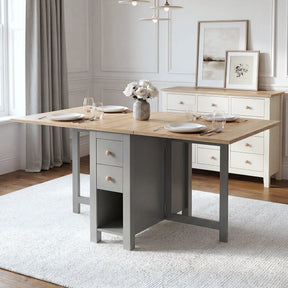 [Grey] Stovra Drop Leaf Dining Table fully extended with both leaves up, set for four with place settings, glasses