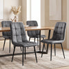 [Grey] Four suede dining chairs around a rectangular wood-effect table, showing tufted fronts and rear profiles.