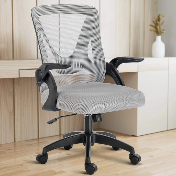 [Grey] With a working desk in the background, the grey mesh chair fits seamlessly into a modern home office setup.