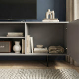Grey TV cabinet with open central shelving and fluted doors, showcasing organized storage for media and home accessories.