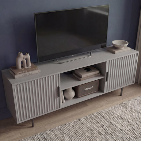 Grey TV media unit with vertical textured doors and silver legs, styled as a modern center for living room entertainment.