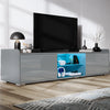 Modern TV stand with a television on a wooden floor in a room.