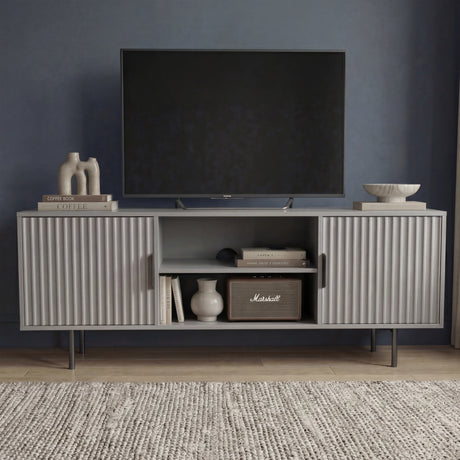 Modern grey TV entertainment unit with vertical fluted doors and silver legs for a contemporary living room aesthetic.
