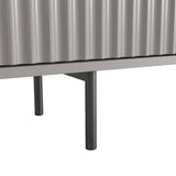 Grey TV unit with slim metal legs and fluted doors, showing an elevated modern design for a living room.