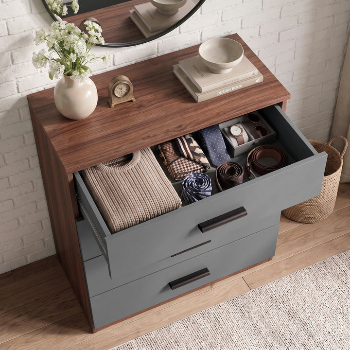 [Walnut] Top-down angle of a grey and walnut chest showing top drawer open with organized ties, belts, and folded clothing