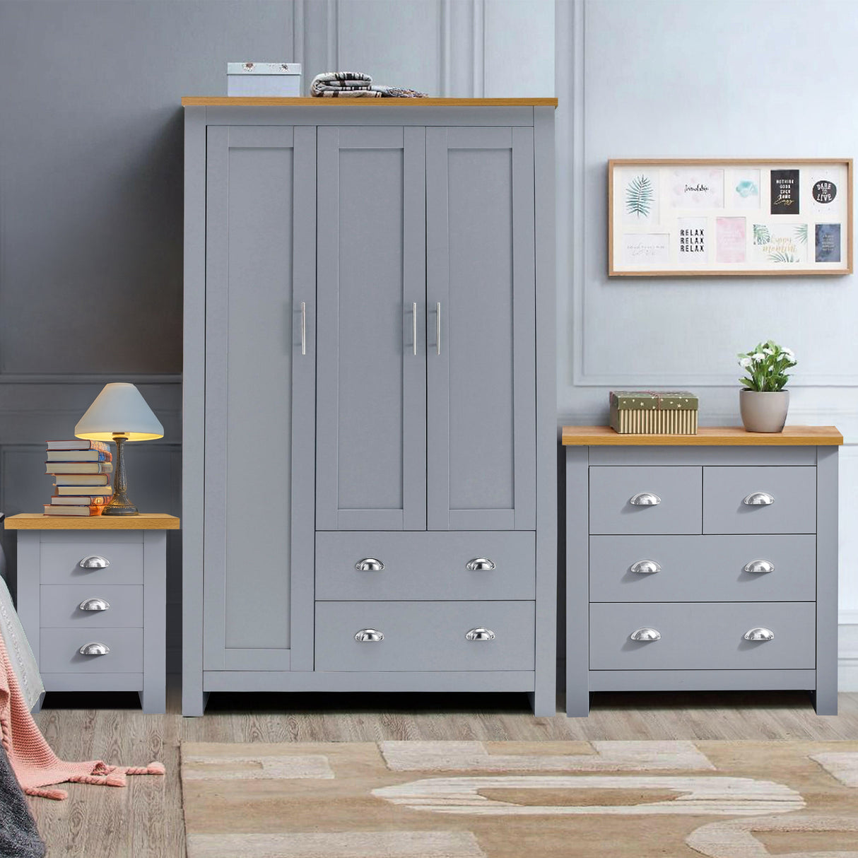 Grey bedroom furniture set including a wardrobe, two dressers, and a bedside table with books.