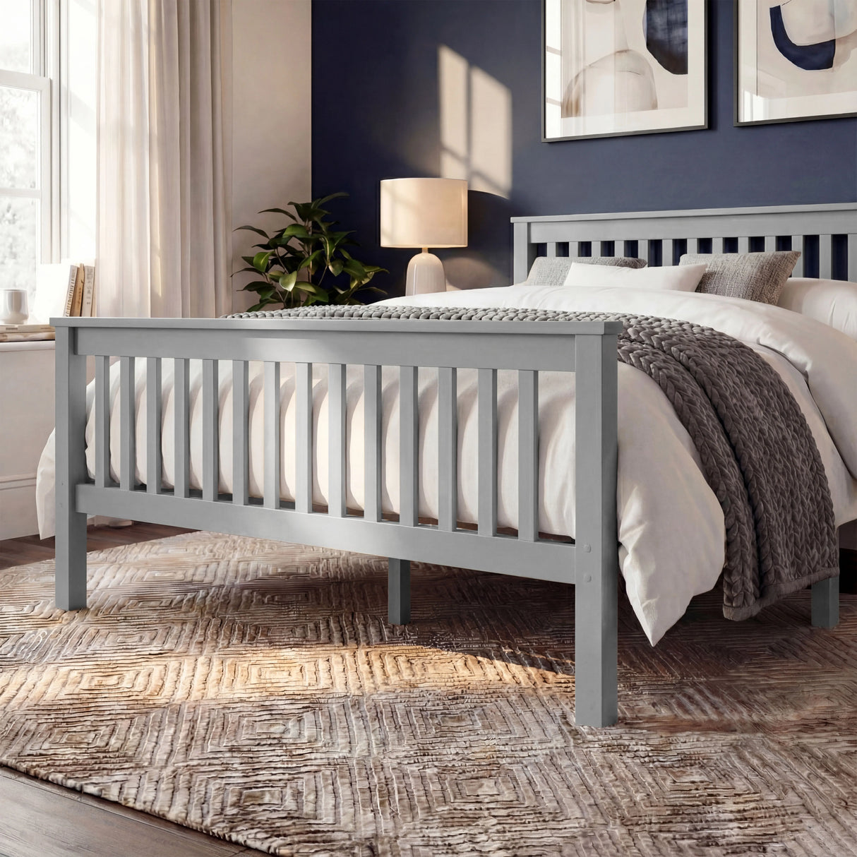 Grey wooden bed frame with vertical slat detailing on both the headboard and footboard, placed in a bedroom