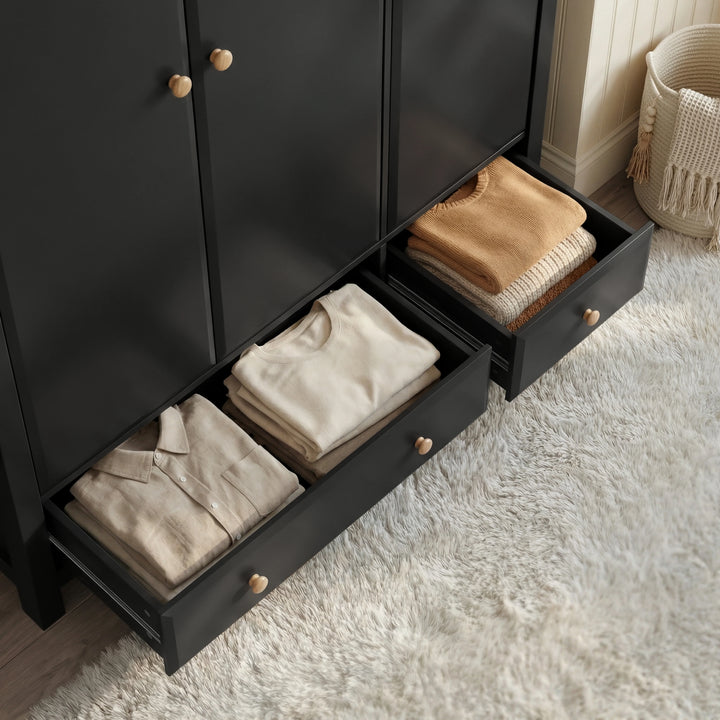 [Black] Haven wardrobe drawer detail, larger and smaller base drawers open with folded clothes inside