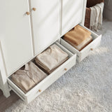 [White] wardrobe with open drawers containing folded clothes on a light gray carpet