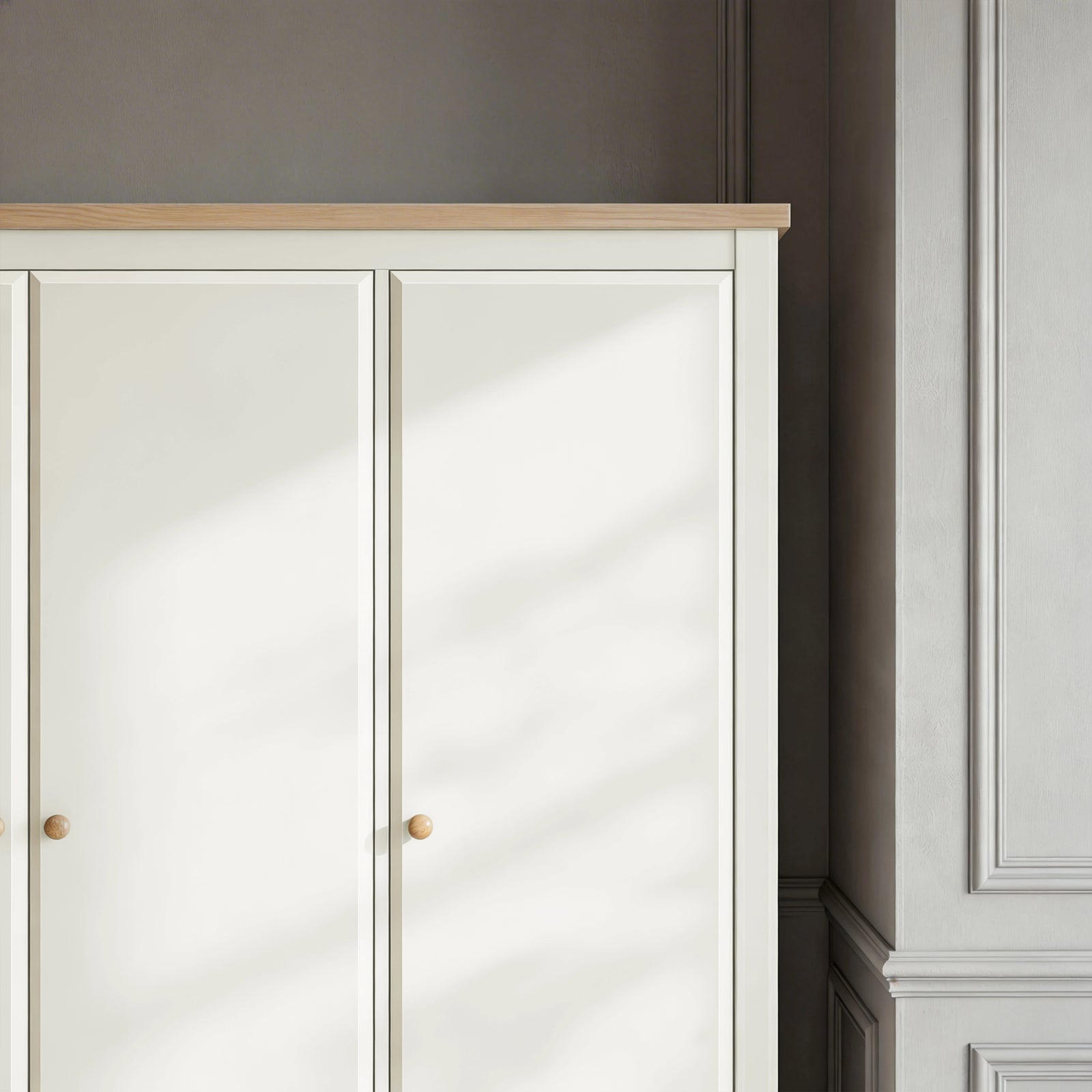 [White] wardrobe with wooden top and knobs in a room with gray walls and white baseboards