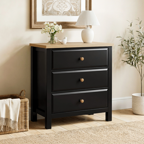 [Black] Haven 3-drawer chest in a bedroom with framed artwork above and plant and basket on the floor beside it
