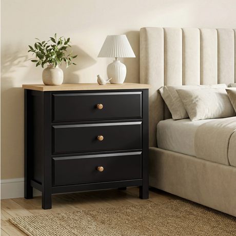 [Black] Haven 3-drawer chest in a bedroom setting with lamp on oak top and upholstered sofa panel behind