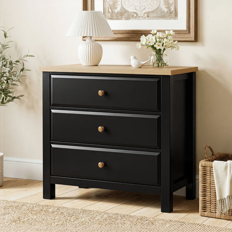 [Black] Haven 3-drawer chest front view in a warm room with flower arrangement and wicker basket on the floor
