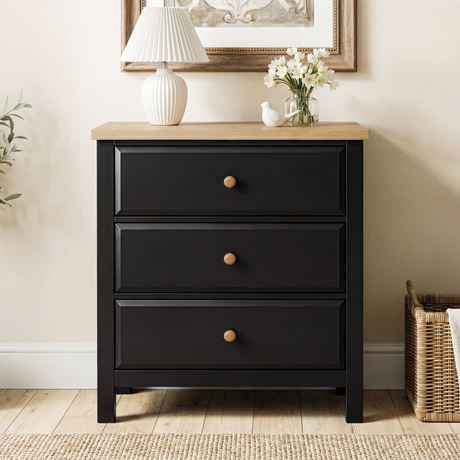 [Black] Haven 3-drawer chest front view in a neutral styled room with floral arrangement on oak veneer top