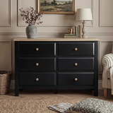 [Black] Haven 6-drawer chest front view from low angle in a living room with lamp and plant in the background
