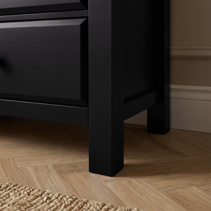 [Black] Bottom corner view of Haven chest of drawers showing painted leg and lower drawer edge