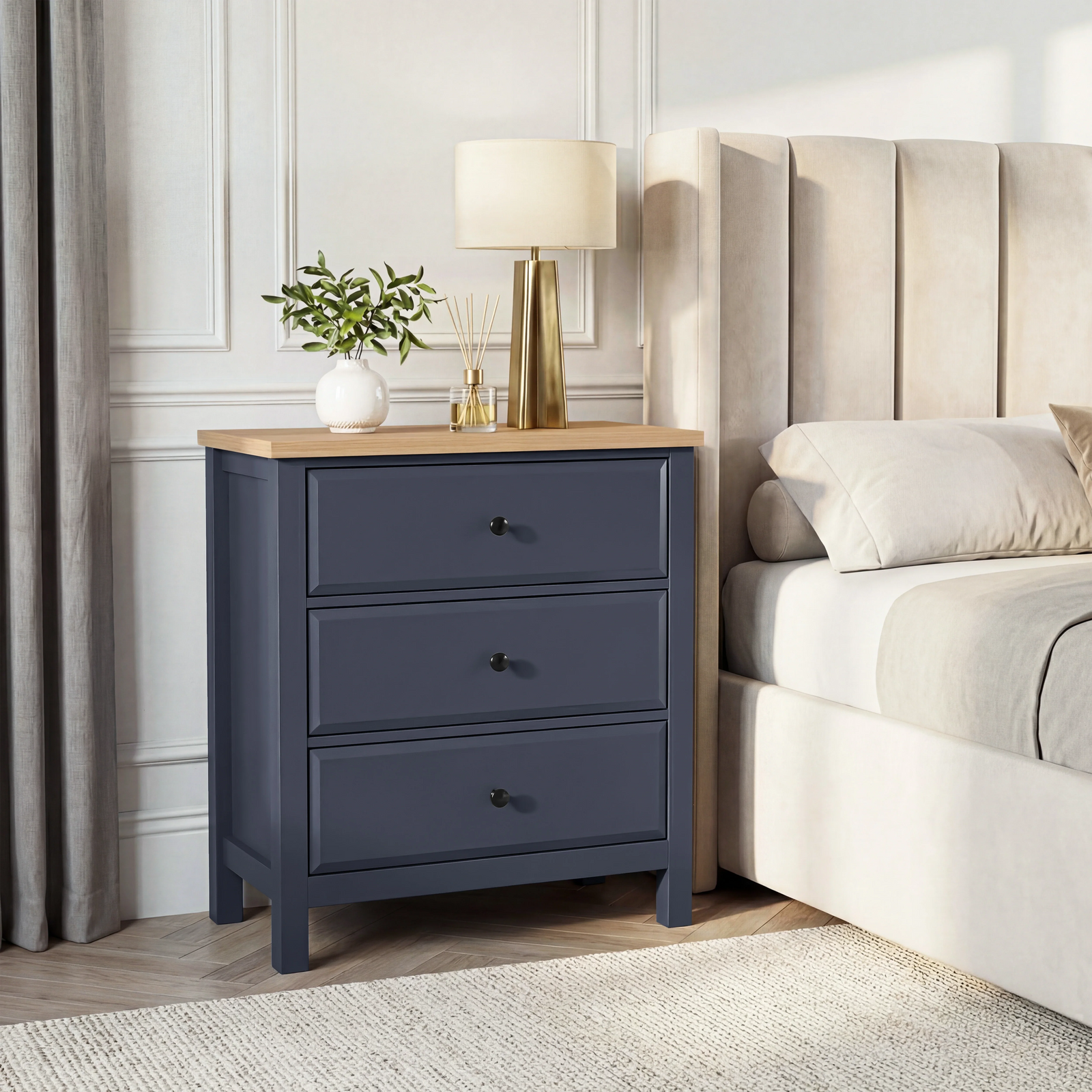 [Blue] Haven 3-drawer chest in a bedroom setting with lamp on oak top and upholstered headboard panel behind