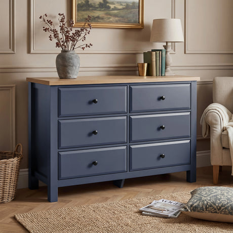 [Blue] Haven chest of drawers in a bedroom setting with artwork above and dried floral arrangement on oak top