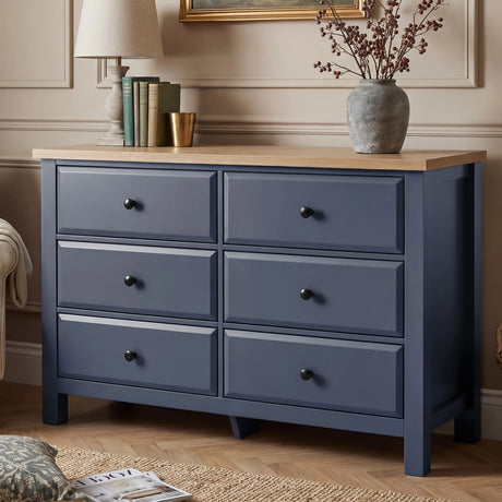 [Blue] Haven 6-drawer chest front view in a styled room with vase, books and dried botanicals on oak top