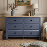 [Blue] Haven 6-drawer chest front view from low angle in a warm room with lamp and floral arrangement on top