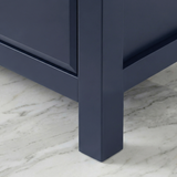 [Blue] Haven chest corner foot view, blue painted tapered leg meeting marble flooring with chamfered base edge