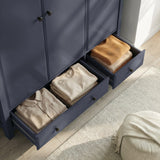 [Blue] Haven 3-door wardrobe with base drawers open on floor beside the unit showing folded garments inside