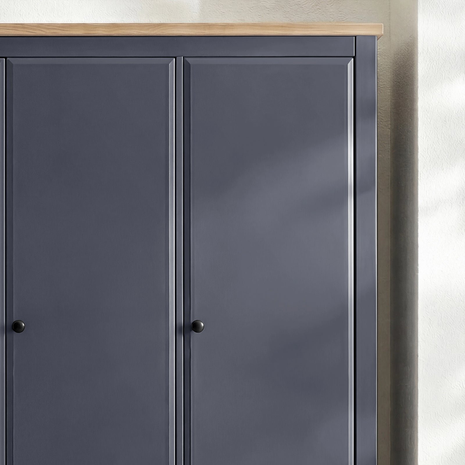 [Blue] Haven wardrobe upper section close-up showing oak veneer top edge and round knob handles on panel doors