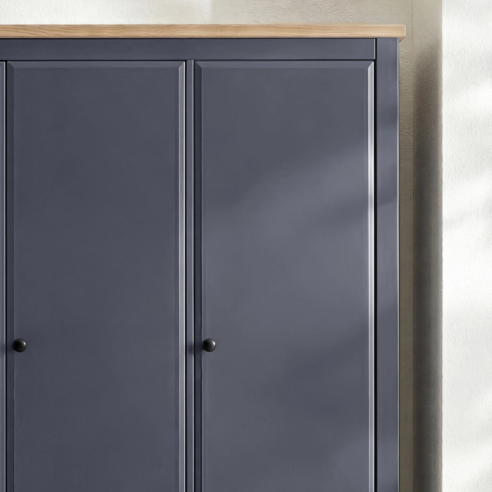 [Blue] Haven wardrobe upper section close-up showing oak veneer top edge and round knob handles on panel doors