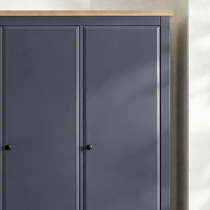 [Blue] Haven wardrobe upper section close-up showing oak veneer top edge and round knob handles on panel doors