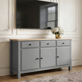 [Grey] Haven 3-door sideboard used as TV stand with wall-mounted flat-screen TV above and gold vase of hydrangeas on oak top