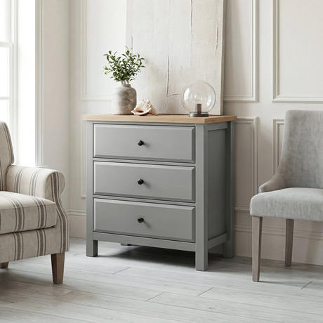 [Grey] Haven 3-drawer chest in a light bedroom with armchair and plant styling in the background