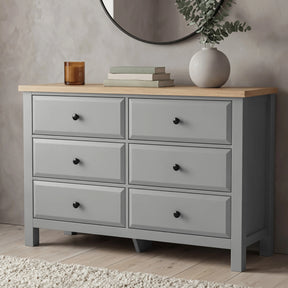 [Grey] Haven chest of drawers front view from low angle with decorative vase and candle on oak veneer top