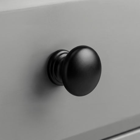 [Grey] Haven chest of drawers close-up of a round solid black wooden knob handle on a painted drawer front