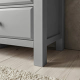 [Grey] Haven chest leg and floor clearance close-up on wide wood planks beside fringed cream rug edge