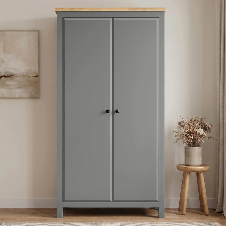 [Grey] Haven Grey 2 Door Double Wardrobe with Shelves and Hanging Rail closed straight-on look next to a wooden stool.